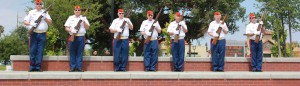 Seven Veterans saluting at a park